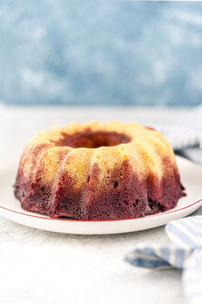 Whole gluten-free almond cherry cake on a plate.